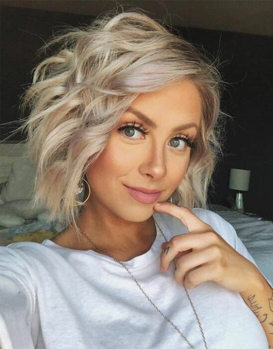 Mujer rubia con melena corta peinada con rizos de ferro