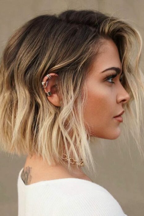 Mujer rubia con melena corta y balayage con rizos