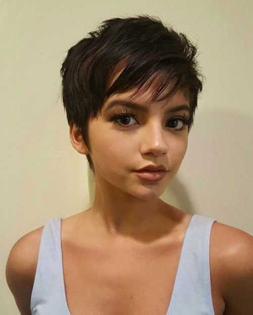 Mujer morena con blusa gris y corte pixie