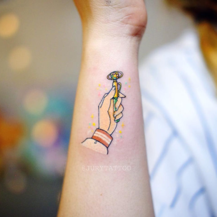 Tatuadora realiza tatuajes encantadores; tatuaje de Sailor Júpiter transformándose en el brazo
