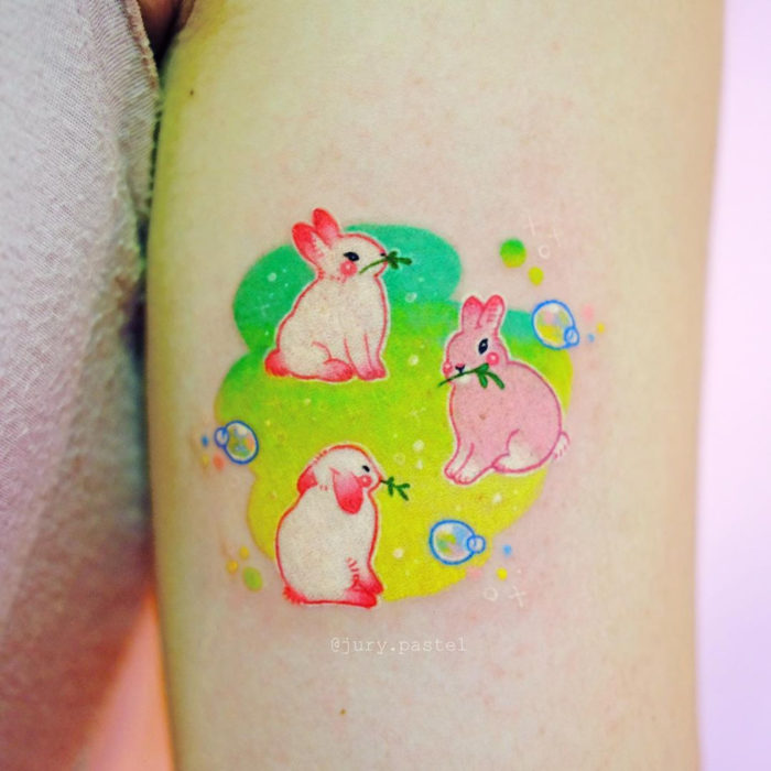 Tatuadora elabora tatuajes adorables; tatuaje de conejos tiernos en el brazo