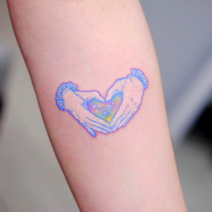 Tatuadora crea tatuajes conmovedores; tatuajes de manos formando un corazón en el brazo