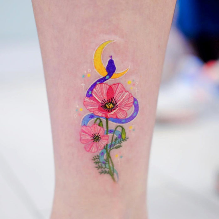 Tatuadora elabora tatuajes fusionando fuerza y suavidad; tatuaje de flores con serpentinas en el brazo