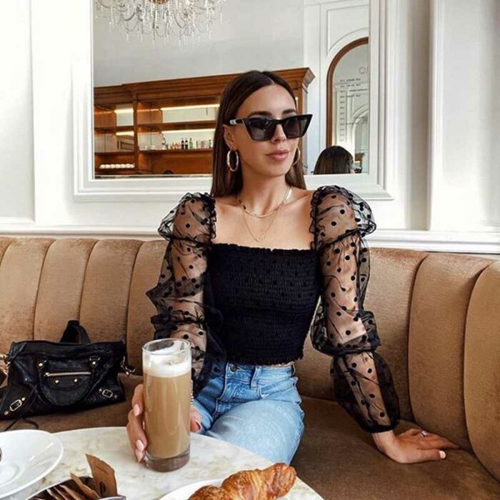 Chica con una blusa negra con transparencias en las mangas