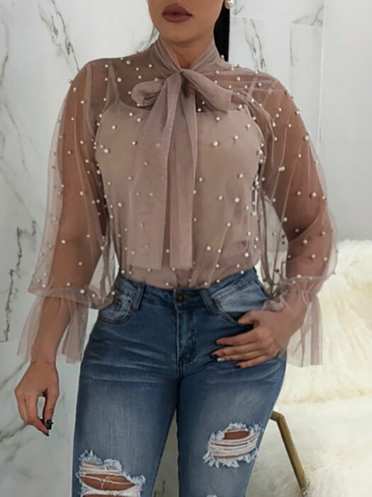 Chica con una blusa rosa con pequeñas perlas plateadas