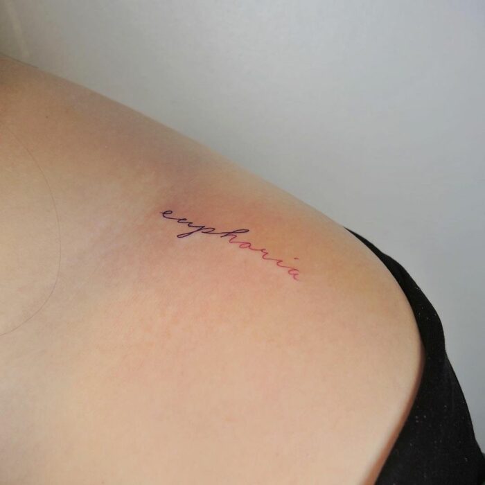 Tatuaje de palabra "euphoria" en el hombro