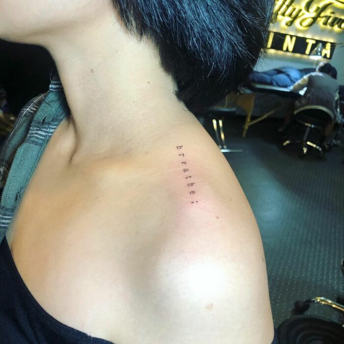 Tatuaje de palabra "breathe" en el hombro