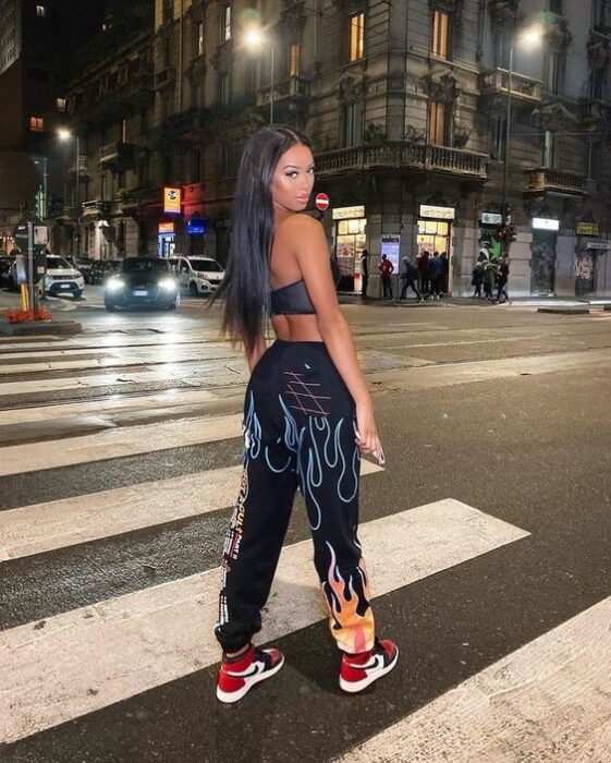 chica en plena avenida mostrando su pantalón holgado en color negro; 13 Ideas para usar pantalones holgados sin perder el estilo