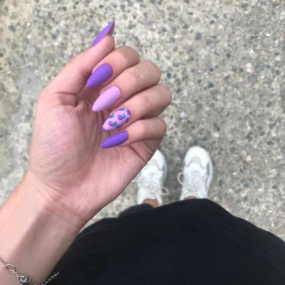 Chica con manicura stiletto en color lila con efecto mate