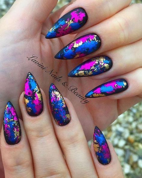 Chica con manicura stiletto en color negro con estampado metalizado en dorado