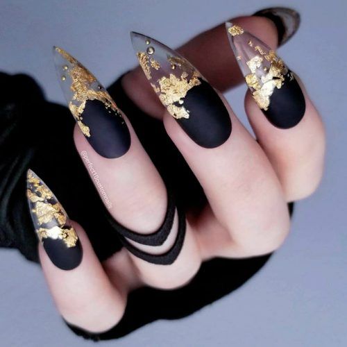 Chica con manicura stiletto en color negro con puntas doradas