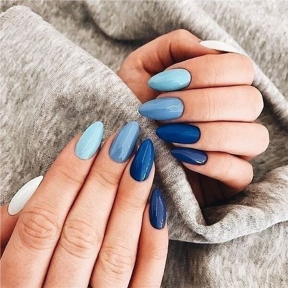 Chica con manicura stiletto en tonos azules