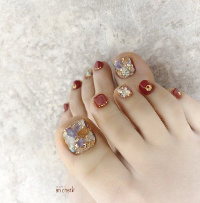 Pedicura en colores dorado y ladrillo