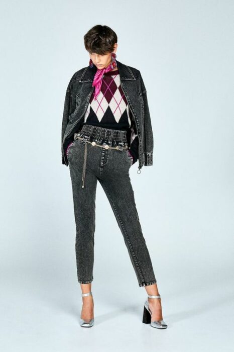 Chica usando un suéter de rombos con jeans y chaqueta
