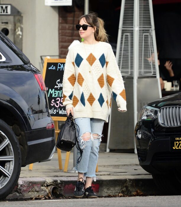 Chica usando un cardigan de rombos con jeans