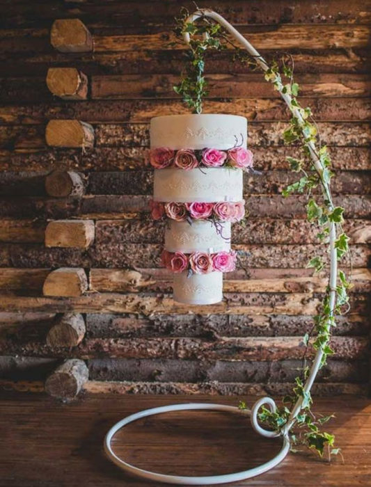 Pastel de bodas volteado pendiendo de un armazón