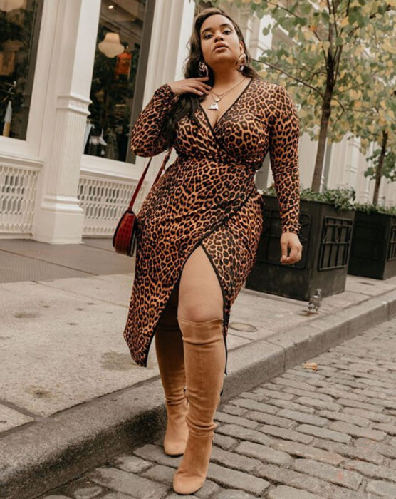 Mujer curvy usando un vestido de animal print, escote en V y botas altas color camel