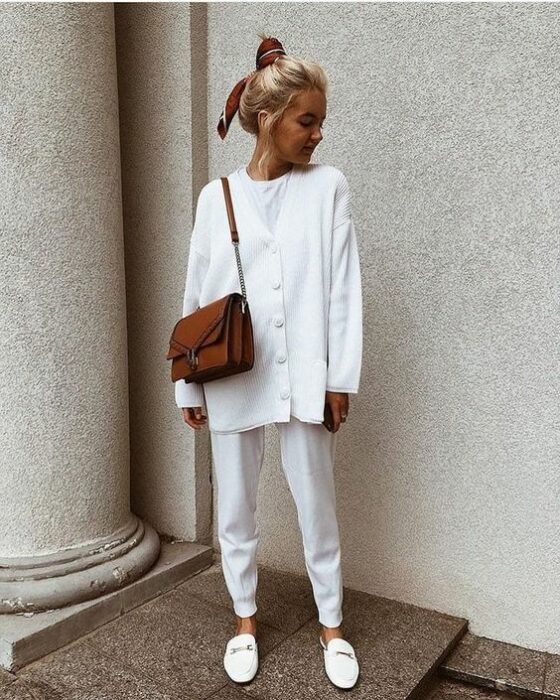 Chica vistiendo un total white look con mules, pantalón, camiseta blanca y cardigans de botones oversize