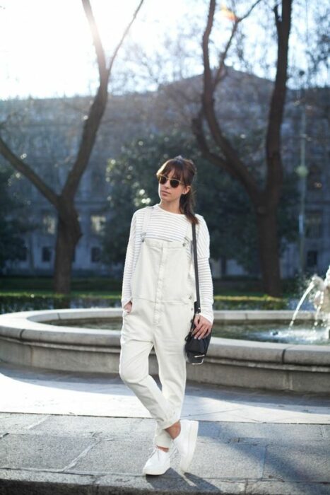 Chica usando un total white look con tenis, pantalón y suéter