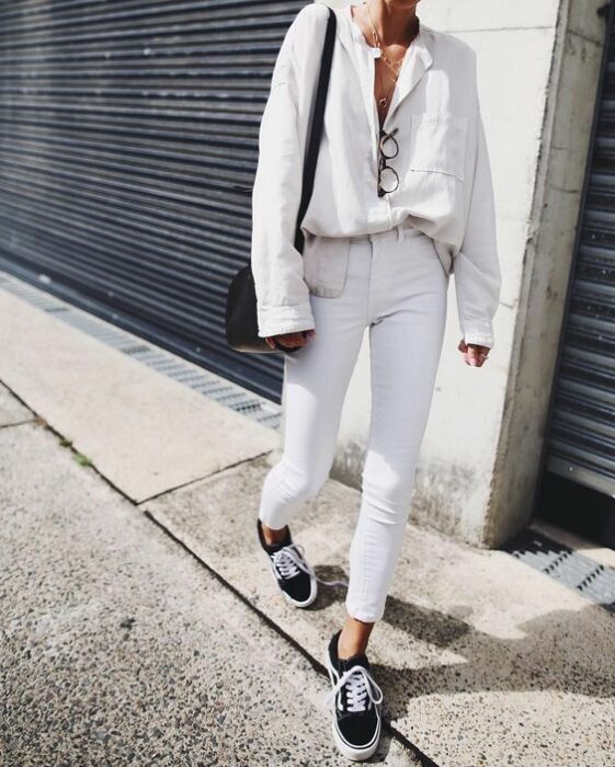 Chica con un total white look de vans, jeans y suéter con botones