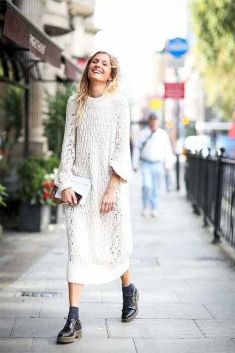 Chica usando un total white look con botines y vestido holgado tejido
