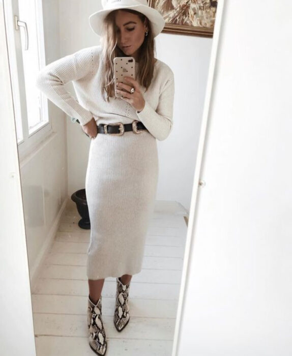 Chica llevando un total white look con falda midi, botas, blusa de manga larga y sombrero