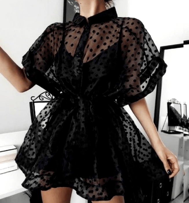 chica con vestido negro de tirantes, tela semitransparente, ajuste en la cintura y mangas cortas abombadas