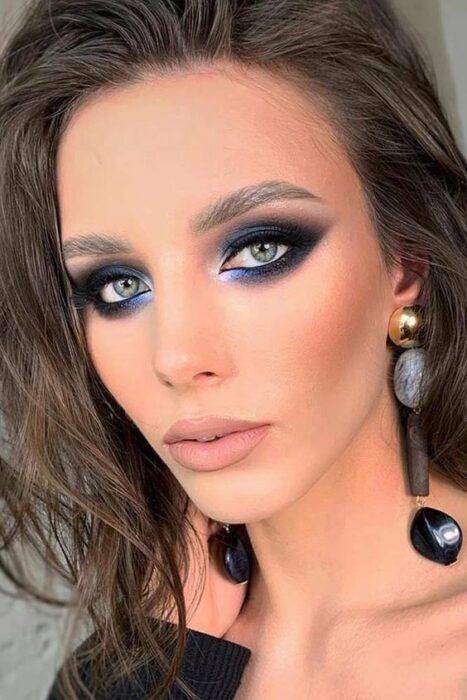 Chica con los ojos maquillados al estilo Smoke Eyes en negro y plateado