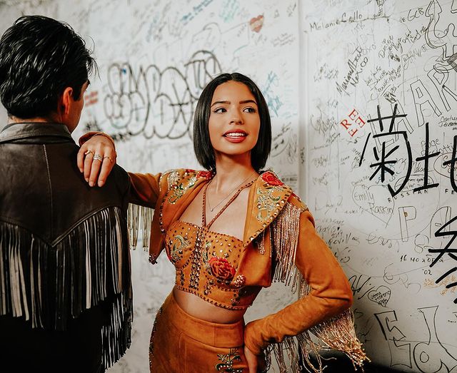 Ángela Aguilar con traje café con adorno de flores