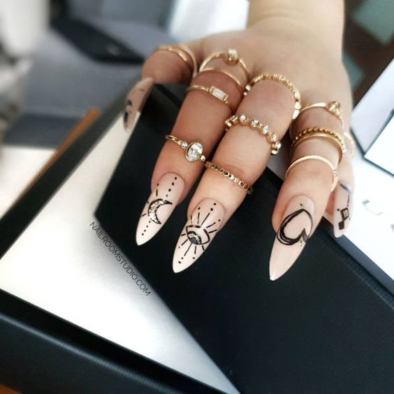 Chica con uñas beige con diseño negro; Uñas para chicas que aman el ocultismo