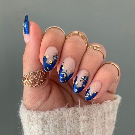 Chica con manicura estilo francés con punta azul y estrellas amarillas; Uñas para chicas que aman el ocultismo