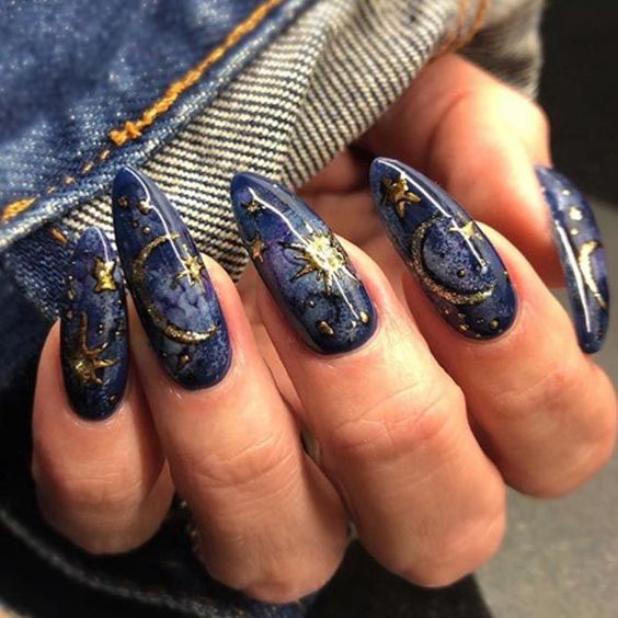 Chica con uñas azules y detalles dorados; Uñas para chicas que aman el ocultismo