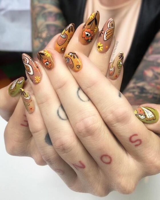 Chica con uñas en tonos marrón con estampados de flores blancas; Uñas para chicas que aman el ocultismo