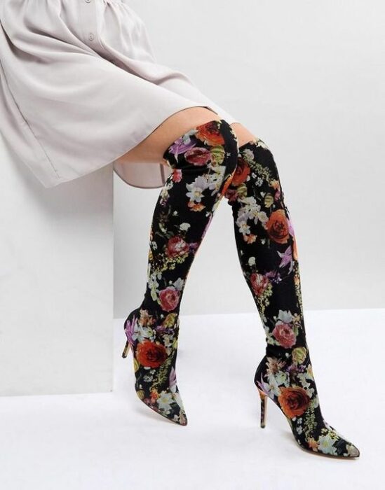 mujer llevando botas largas con bordados florales; 13 Zapatos bordados que te gustaría tener en tu guardarropa