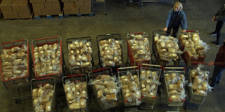 Chica con carros de supermercado rellenos de pan artesanal