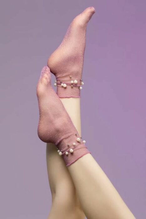 Calcetas encantadoras con semi transparencia en color rosa palo y perlas decorando el tobillo