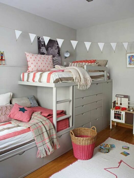 Habitación blanca con muebles grandes y literas que incluyen cajones