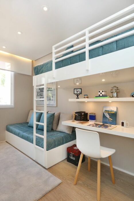 Habitación blanca con mueble grande para cama de dos plantas y cobijas azules