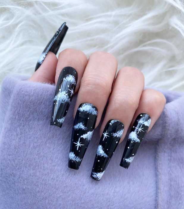Manicura con diseño de cielo y nubes; uñas largas cuadradas pintadas con esmalte negro