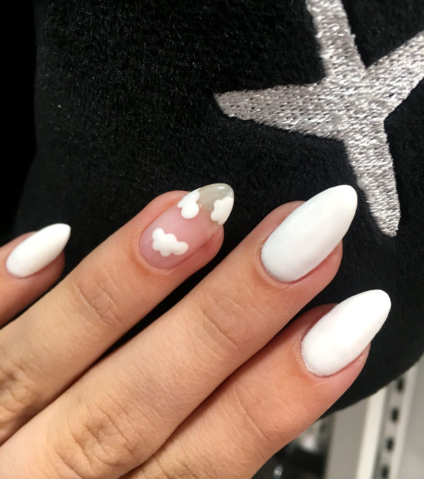 Manicura con diseño de cielo y nubes; uñas en forma de almendra pintadas con esmalte blanco