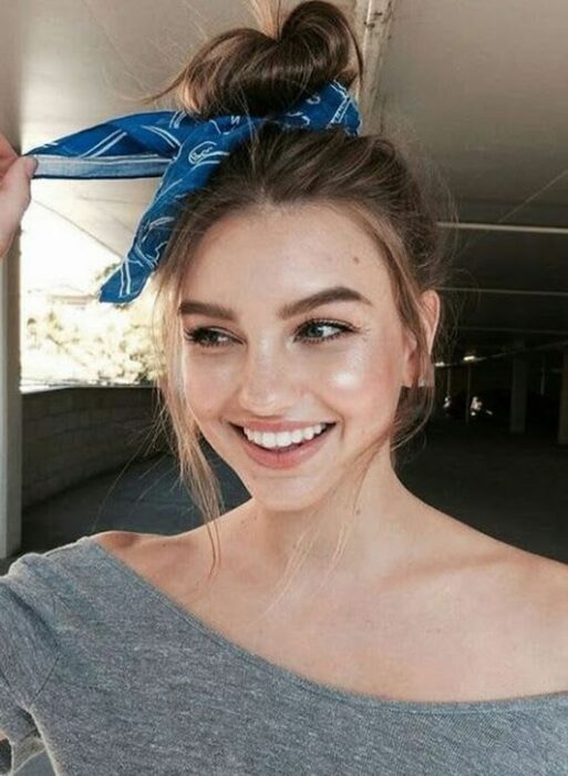 Chica con un bun alto y pañoleta azul; Peinados para cuando acabas de bañarte
