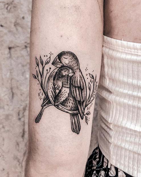 Tatuaje en el brazo para mamás de ave con su cría en una rama