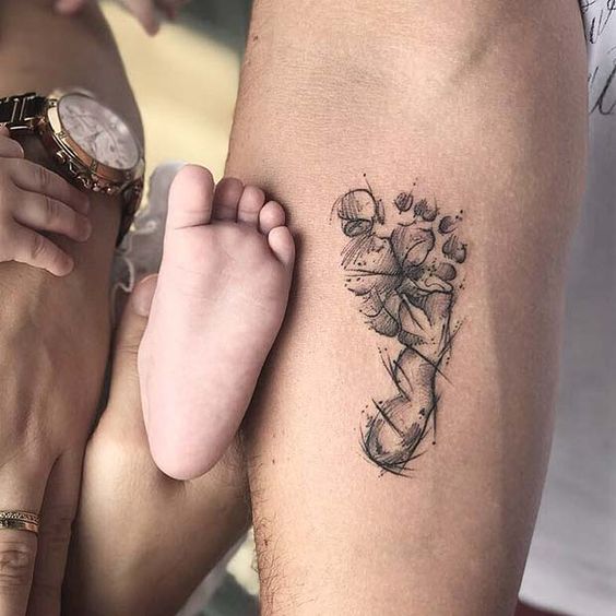 Tatuaje en el brazo de piecito de bebé en tinta negra