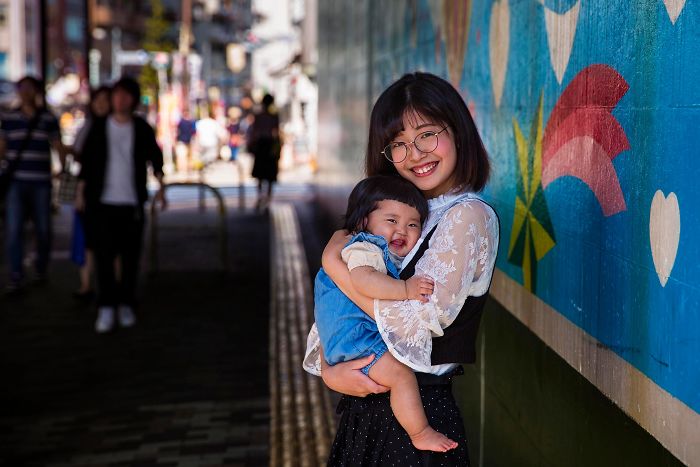Fotografía de Mihaela Noroc, madre cargando a su hijo en una estación de metro