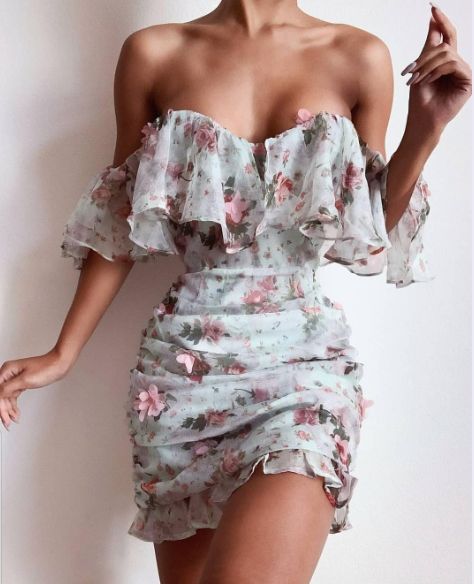 Chica con vestido azul con estampado de flores rosas con tela delgada y arrugada