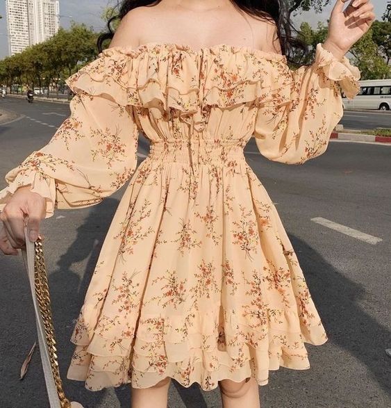 Vestido amarillo con hombros bajos con olanes y estampado de flores naranjas