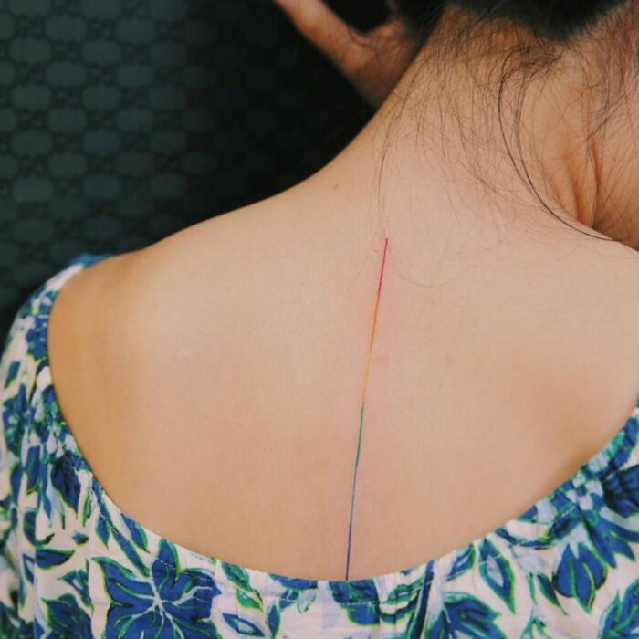Diseños sutiles de tatuajes de arcoíris en línea en la espalda
