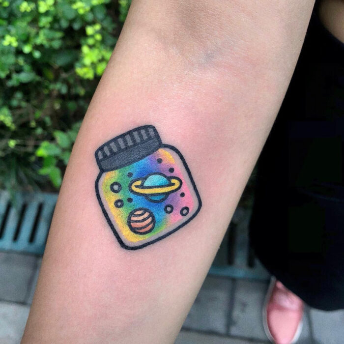 Diseños kreativos de tatuajes de jarra de vidrio con arcoíris y planetas en el brazo