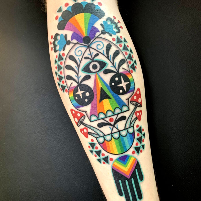 Diseños icónicos de tatuajes de arcoíris y calavera en el brazo