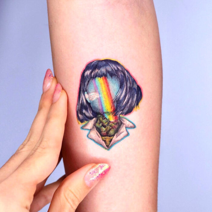 Diseños hermosos de tatuajes de mujer con cara de arcoíris en el brazo